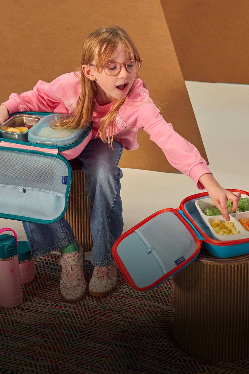 girl reaches into hydro flask kids lunch box to get food