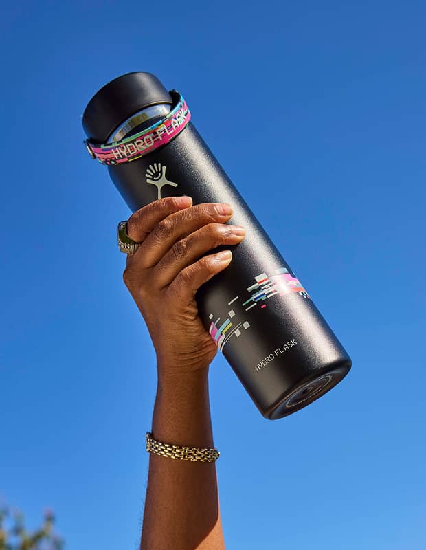 hand holding a limited edition hydro flask glitch bottle into the air