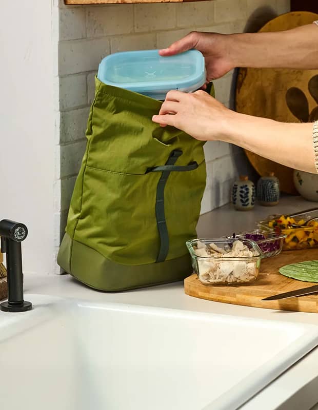 person putting hydro flask tupperware into a hydro flask carryout lunch rolltop
