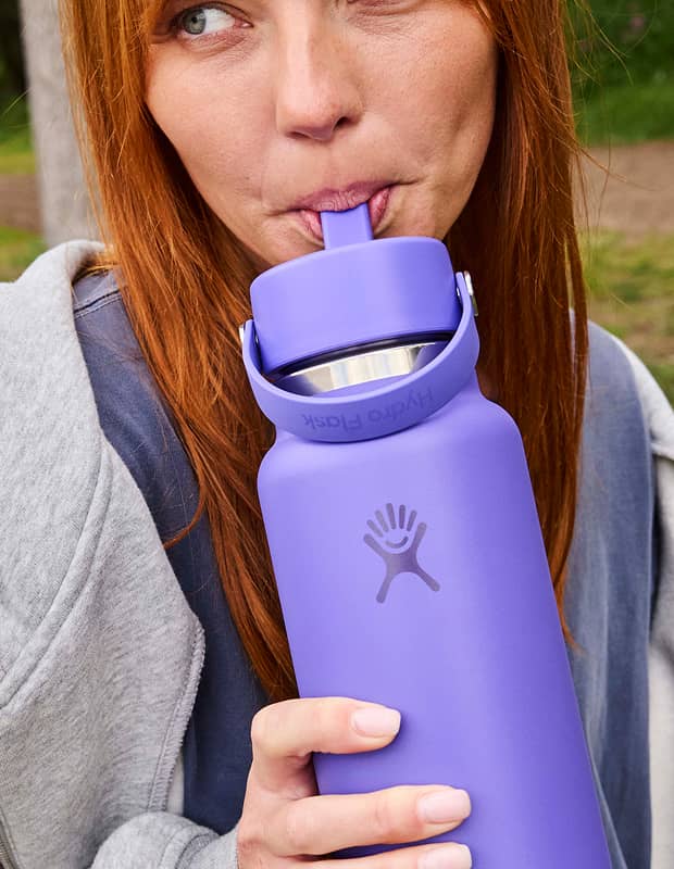 Female drinking out of a Utopia Purple Hydro Flask straw bottle